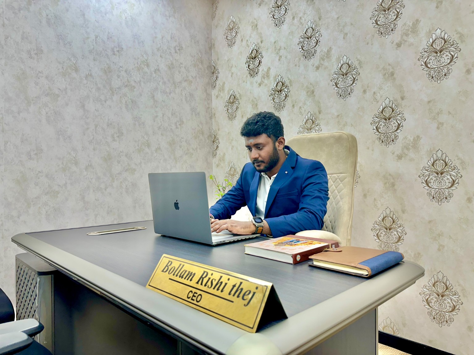 Bollam Rishithej working at his office desk