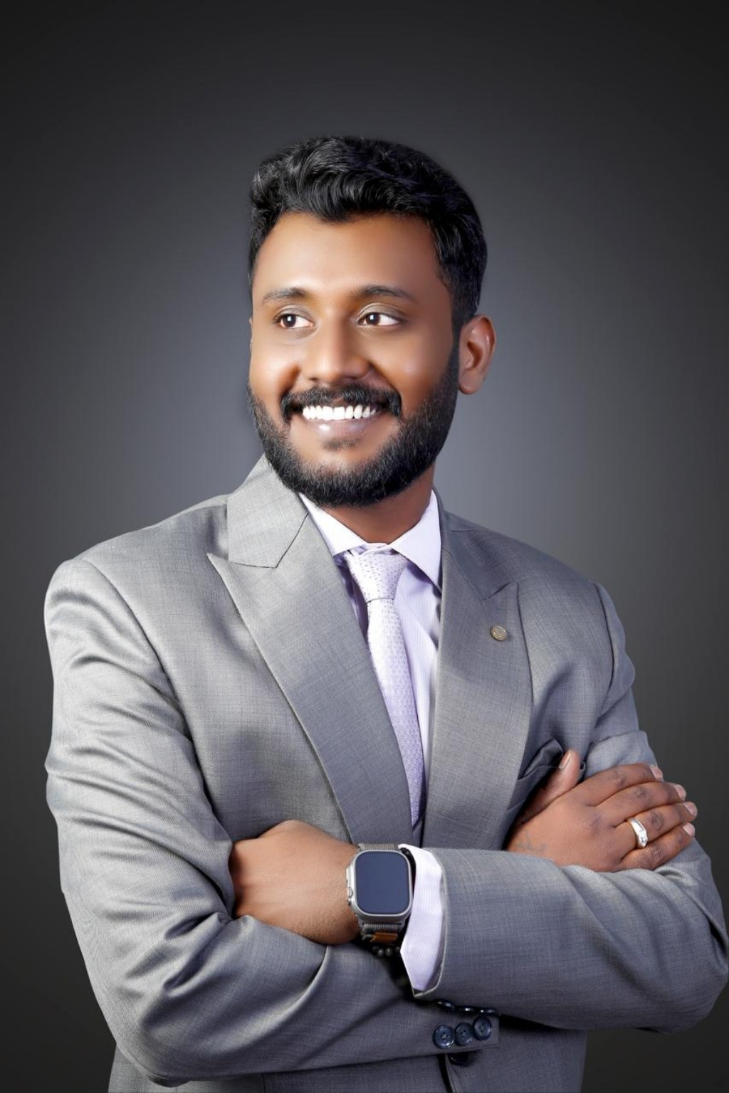 Rishithej smiling in a grey suit